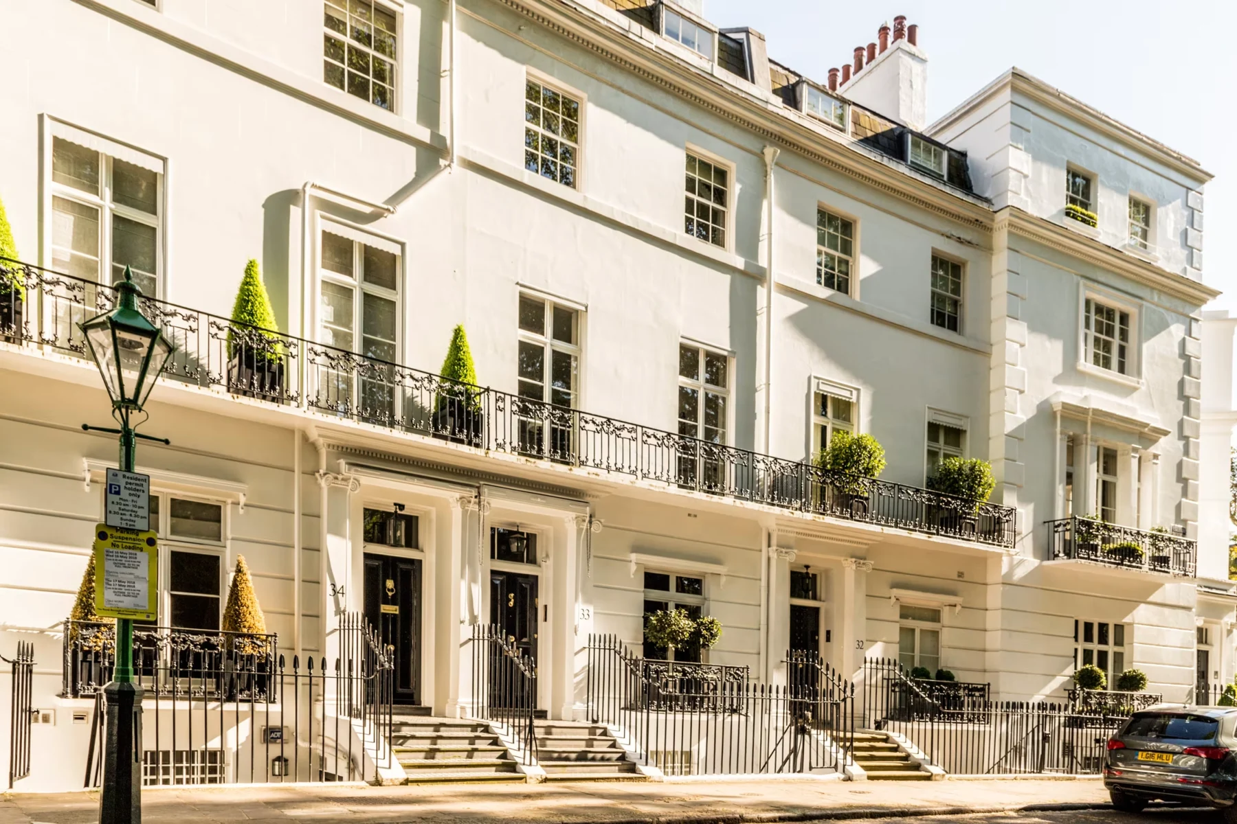 Elegant white townhouses on a tree-lined London street